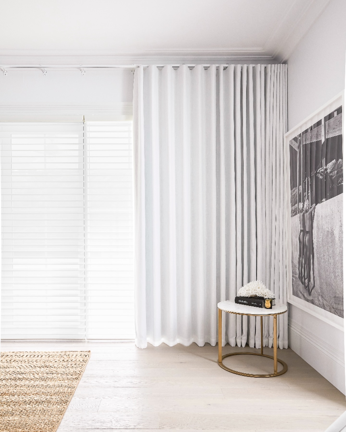 White venetian-style blinds with artwork